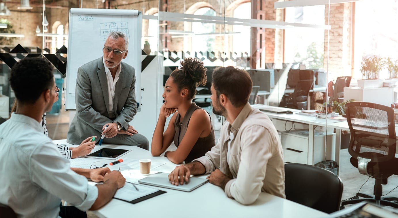 Manager speaks to staff in business meeting