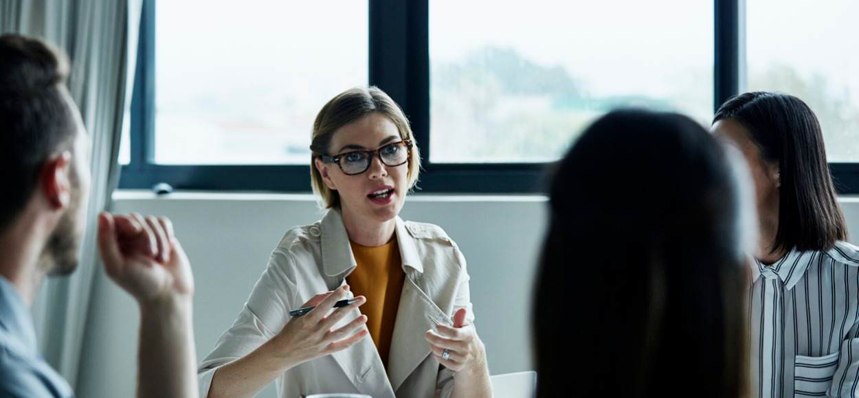 business woman discussing with three colleagues in office