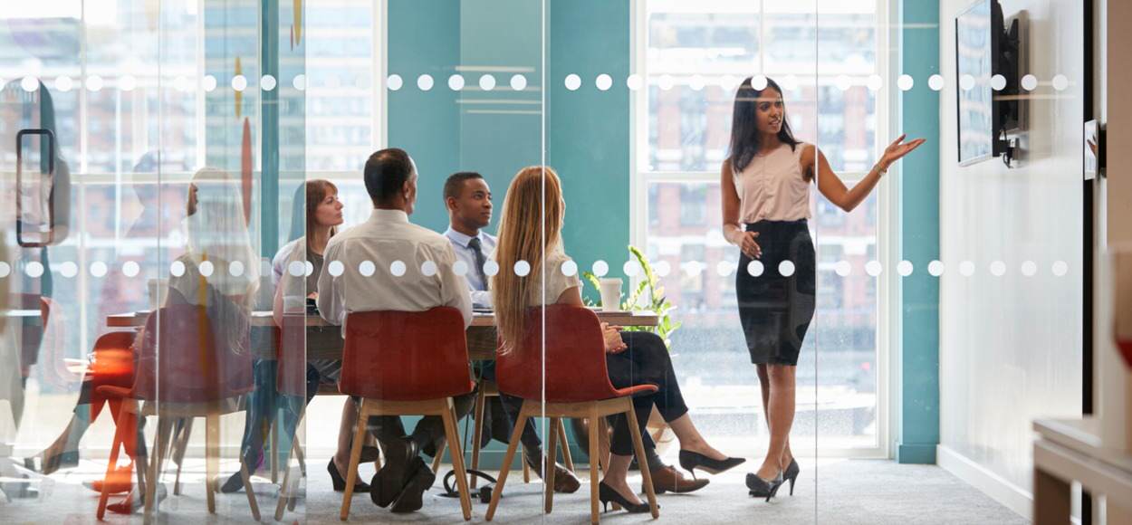 Female boss carries out presentation in front of colleagues in office