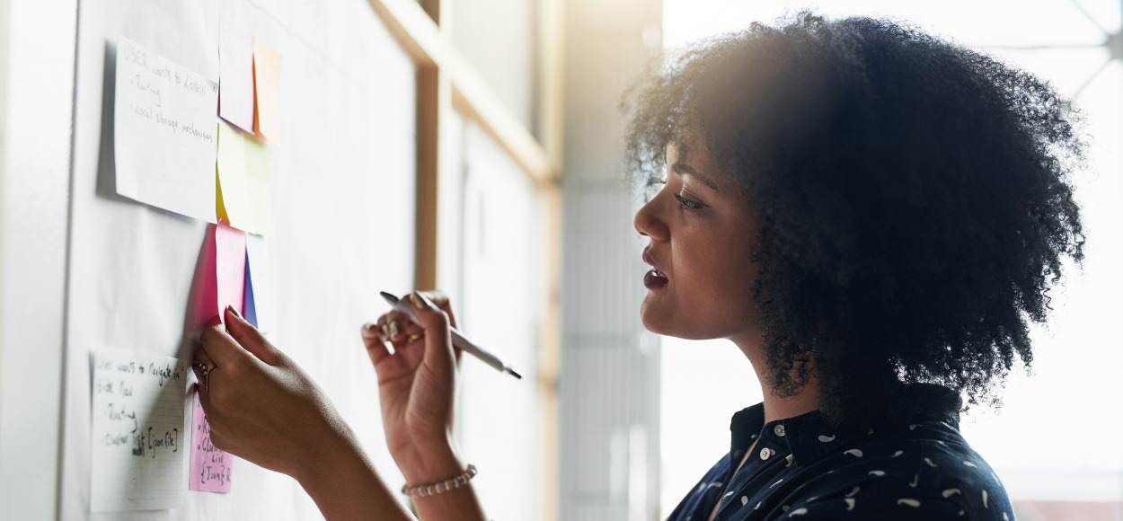 Woman plans ahead using sticky notes on a board