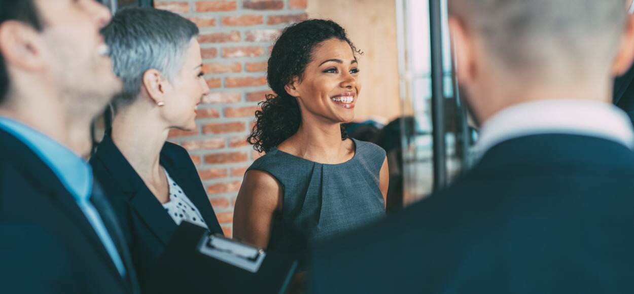 Colleagues talking and smiling in business clothes