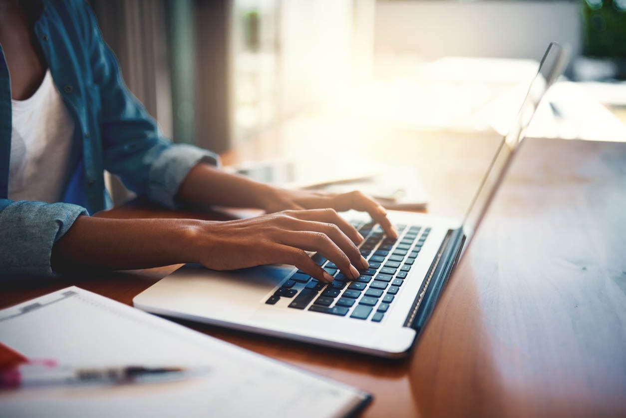 Woman types on laptop