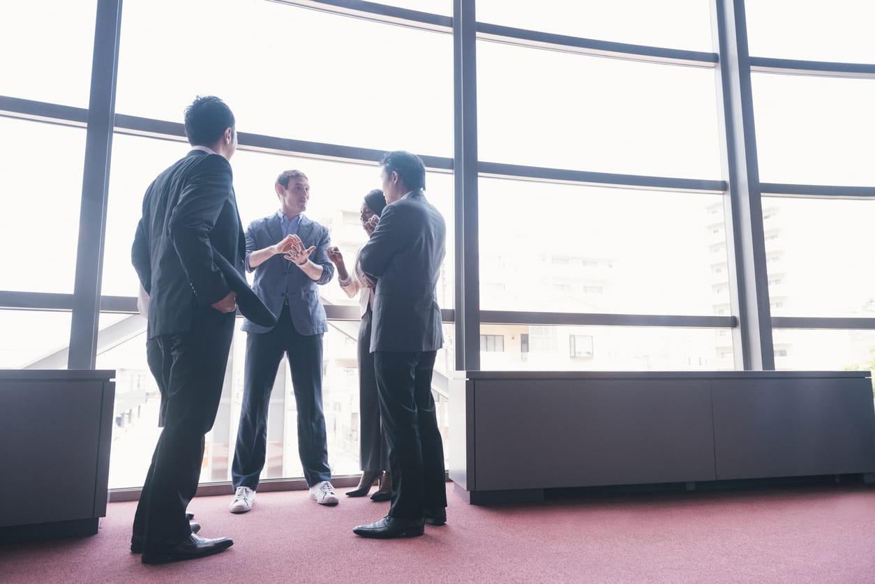 This is a horizontal, color photograph of a tech startup entrepreneur speaking to an international group of business people to discuss the growth of his company. Photographed with a Nikon D800 DSLR camera in Kyoto, Japan.