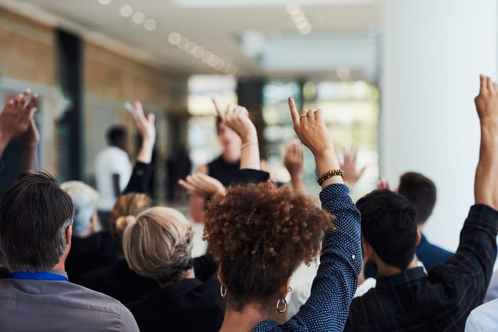 workers holding their hands up to ask questions