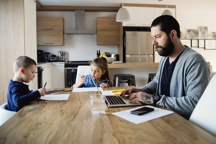 man working from home with kids at kitchen table