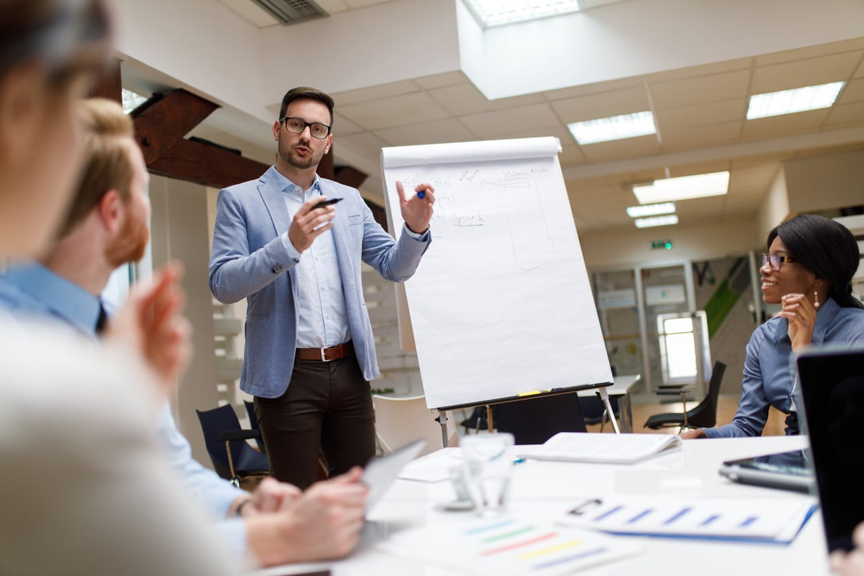 man pitching ideas to his team