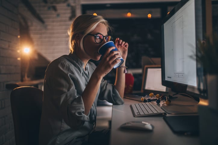 woman drinking coffee working late