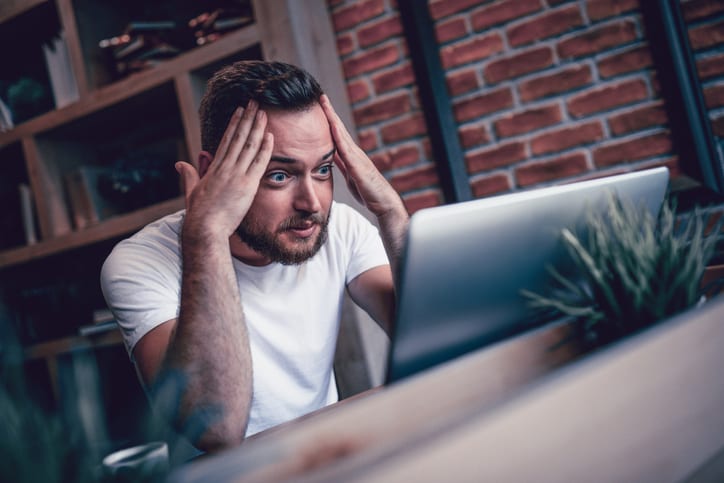 shocked man looking at his computer