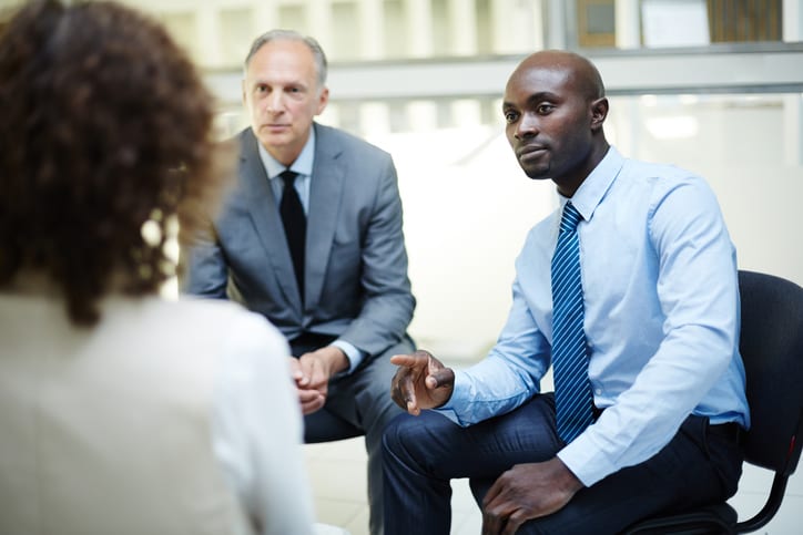 businessmen listening to colleague