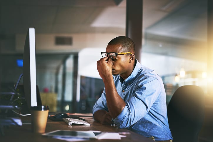 stressed businessmen sat at desk