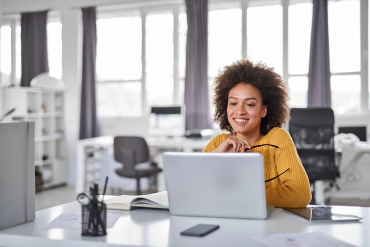 businesswoman smiling at her laptop