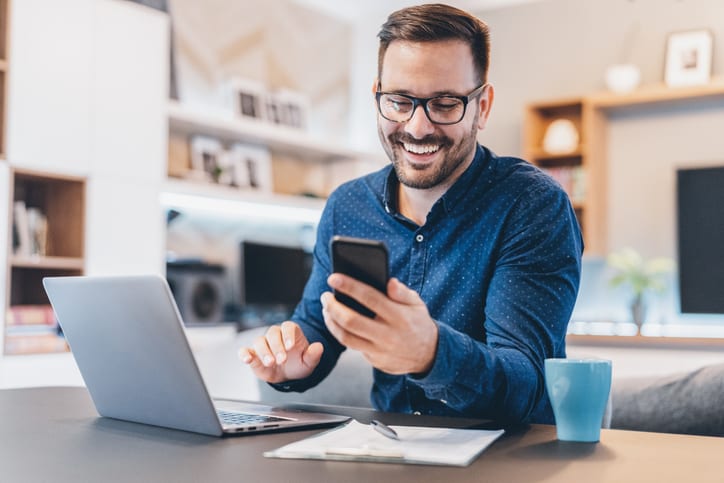 businessman smiling at his mobile phone