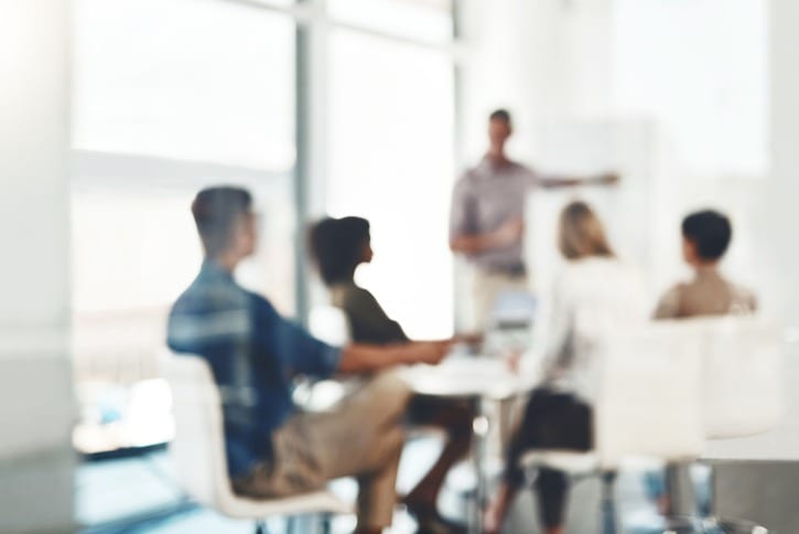 blurred shot of colleagues in meeting room