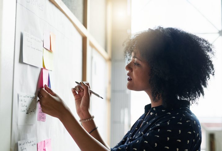 businesswoman writing on sticky notes