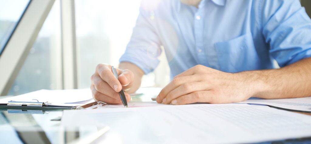 Cropped photo of mans hands writing on a piece of paper