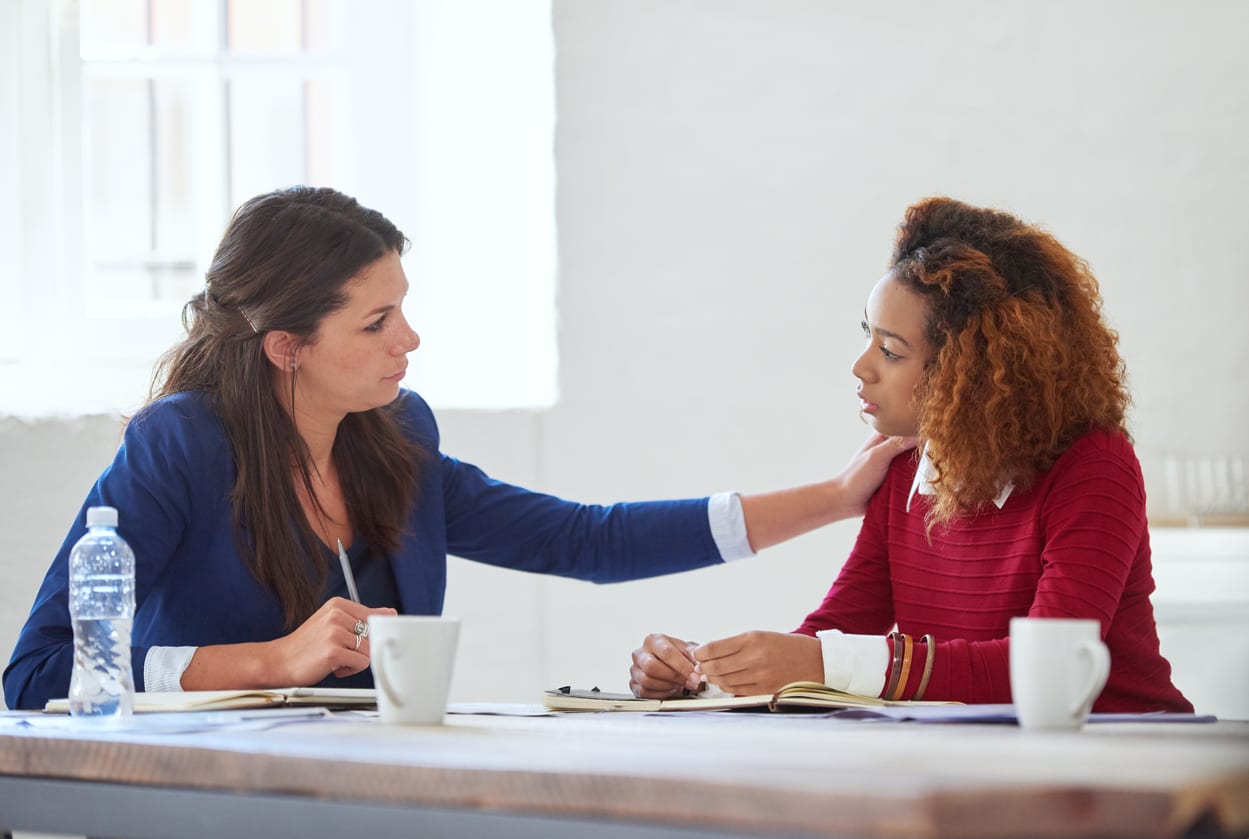 Cropped shot of a young businesswoman consoling her colleague over lunch