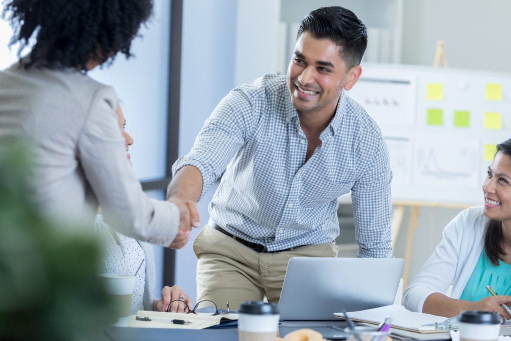 smartly dressed male shaking hands with female employee