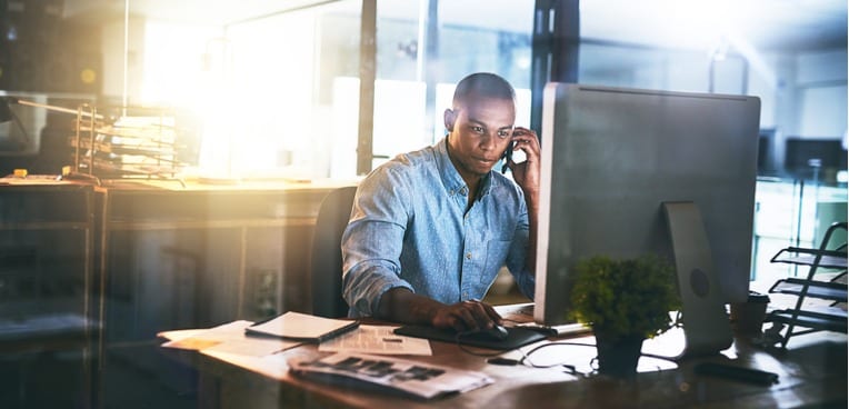 image of man working at his desk and on the phone