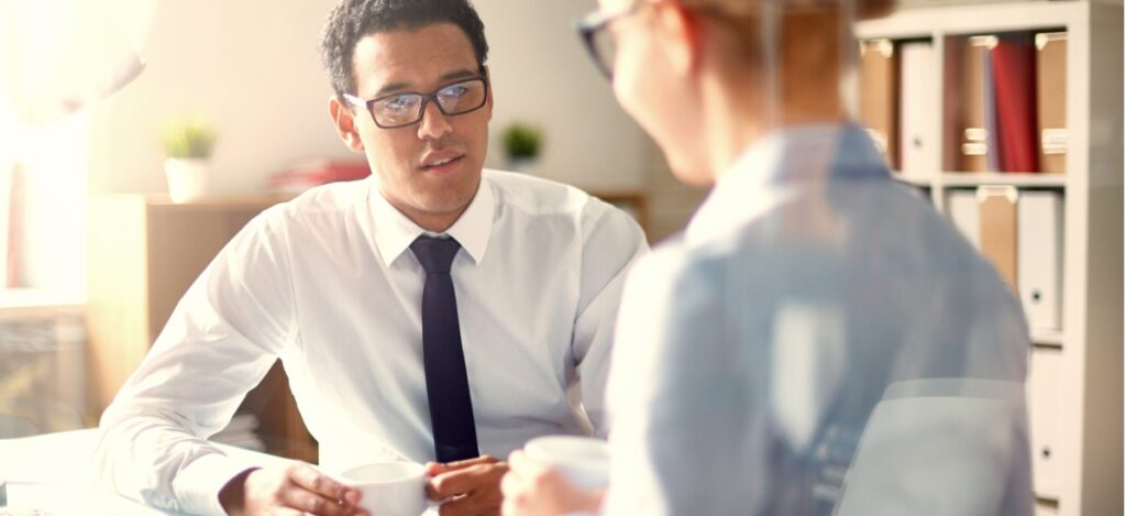 Business women and man have cup of tea in meeting