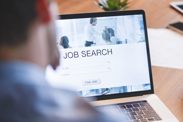 Businessman looking at job search website on a laptop computer.