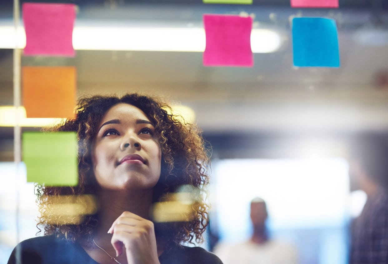 woman looking at post-it notes