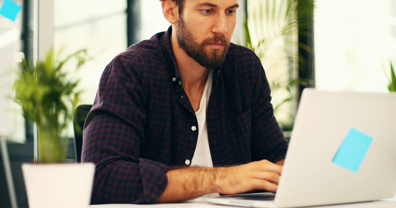 Young employee working on a laptop focused