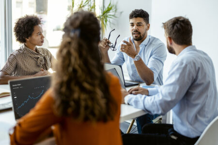 Confident and successful team. Group of young modern people in smart casual wear discussing business while sitting in the creative office