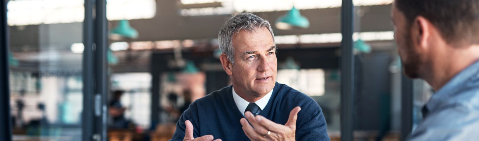 Shot of a mature businessman having a discussion with a colleague in an office