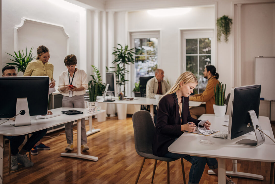 Group of people working in big modern office together. 