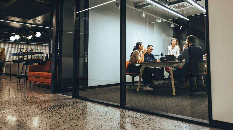 Business colleagues having a meeting in a transparent boardroom.