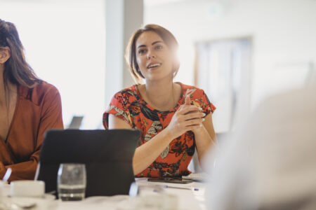 Attractive female employee sitting at meeting table looking thoughtful, ideas, strategy, focus