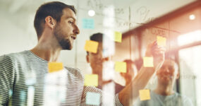 Cropped shot of a group of young designers using sticky notes during a brainstorming session