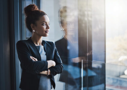 Shot of a young businesswoman looking out the window in an office