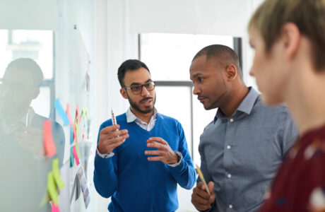 Multi-ethnic group hipster trendy business people with Indian boss discussing during a brainstorm session for their small company