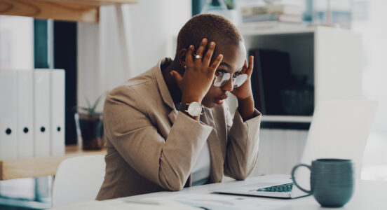 Shot of a young businesswoman looking stressed out while working on a laptop in an office