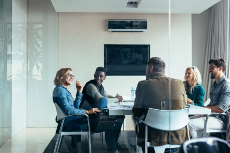 Female manager leads brainstorming meeting in design office. Businesswoman in meeting with colleagues in conference room.