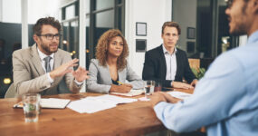 Shot of a group of businesspeople interviewing a candidate in an office