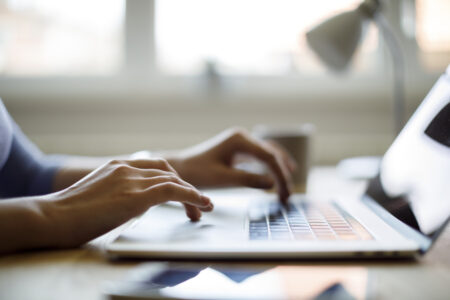 Cropped image of hands typing on a keyboard