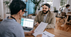 Male having an interview with possible female boss reading his cv