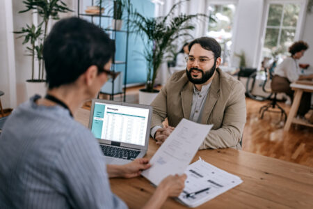 Male having an interview with possible female boss reading his cv