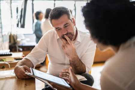 Female and male employee looking at a tablet intensely 