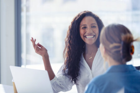 two female employees laughing and smiling at each other