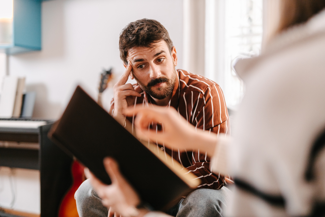 Male employee looking stressed in casual meeting with boss