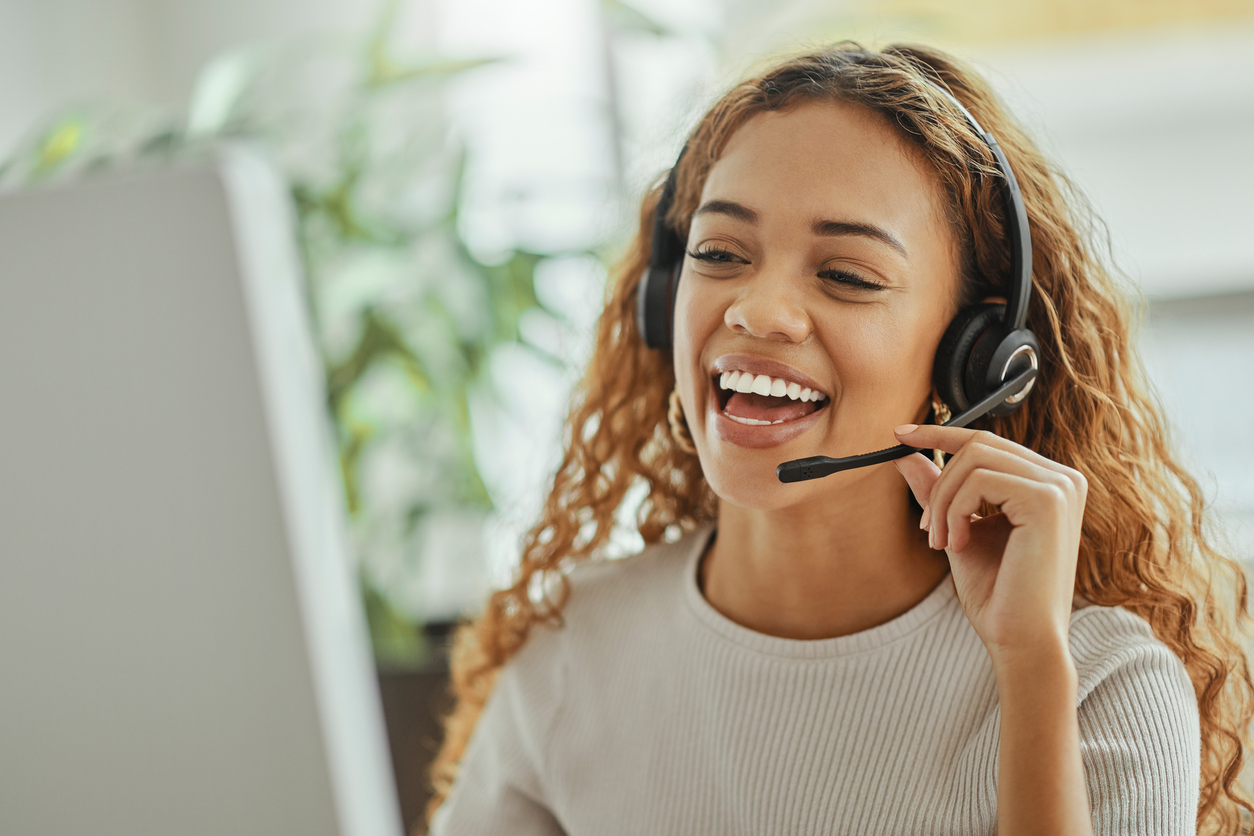 Happy female employee speaking to a customer on the phone