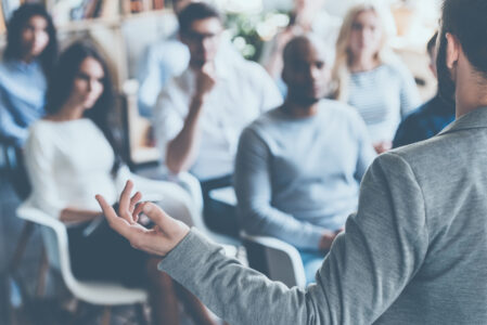 Photo of a crowd of co workers engaged in a presentation