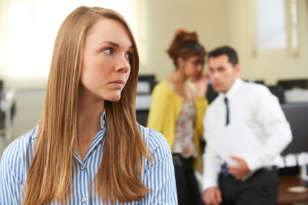 Businesswoman Being Gossiped About By Colleagues In Office