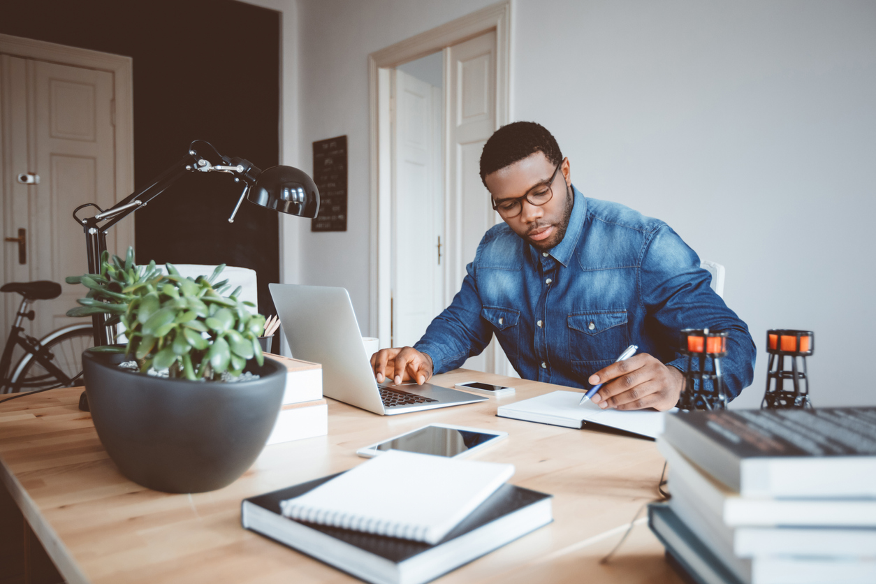 Male boss writing notes in notepad