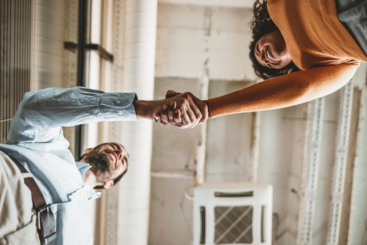 two employees shaking hands from above