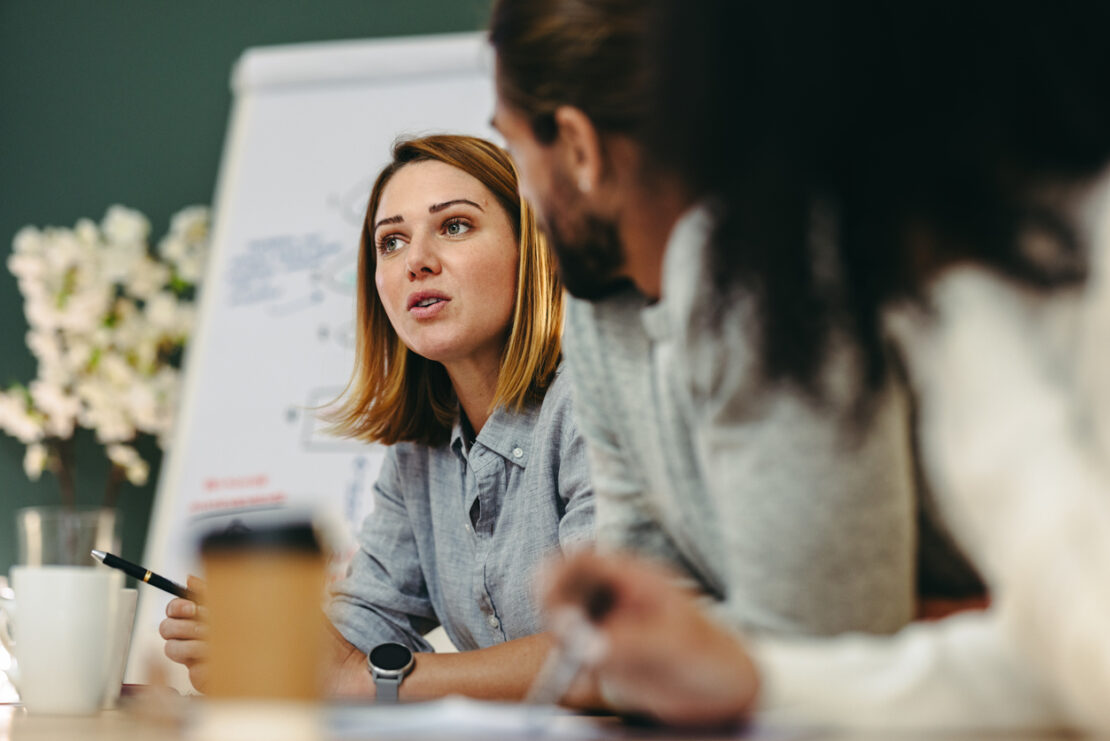 Focused image on female employee leading team meeting