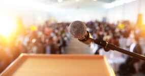 Empty microphone in a room full of people blurred out